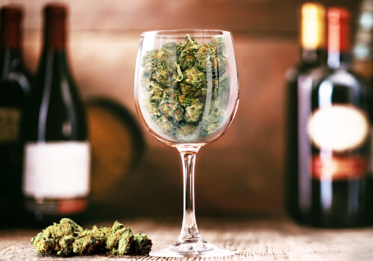 Cannabis buds in a wine glass symbolizing a healthy alternative to alcohol