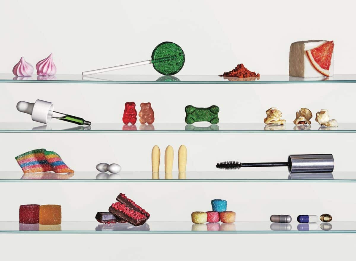 Alt text: Glass pharmacy shelves displaying a variety of CBD-infused products including gummies, tincture droppers, capsules, edibles and topicals — illustrating the mainstreaming of cannabinoids across consumer product categories