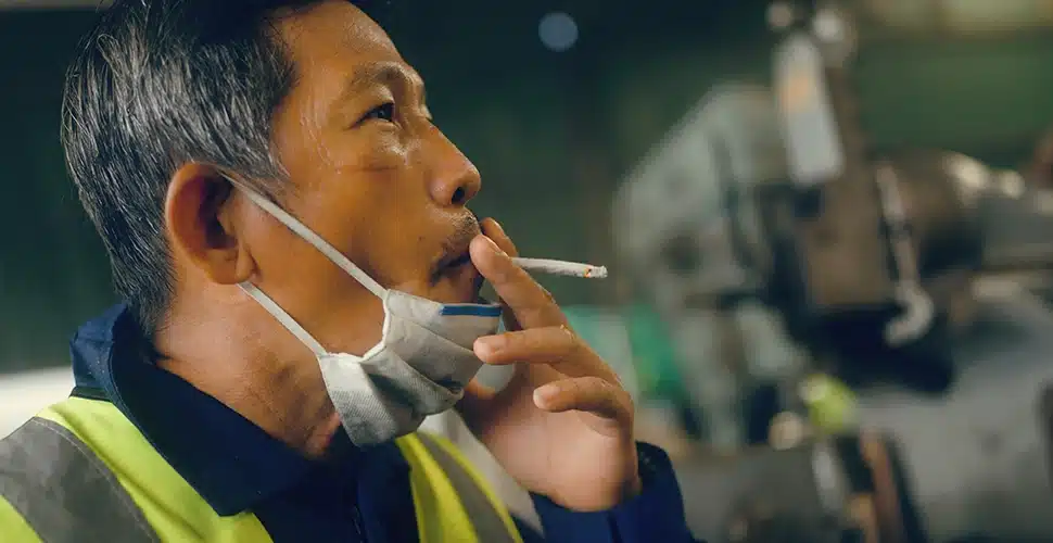 Employee on a smoking break outside workplace building representing cannabis use and workplace drug testing policies