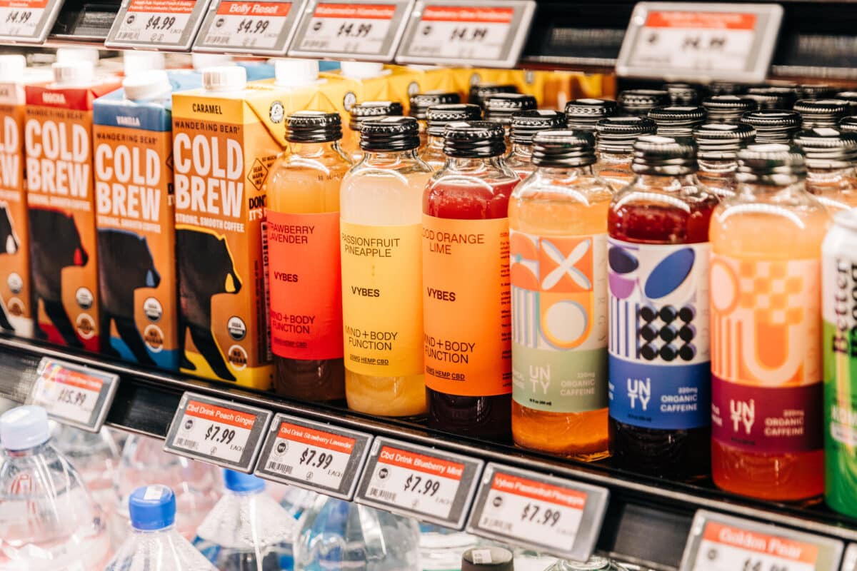 CBD beverages and cold brew products displayed on store shelf with price tags showing American-made options